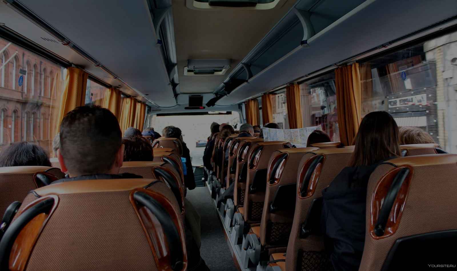 Yellow Van Rides charter bus providing group transportation on a highway at sunrise