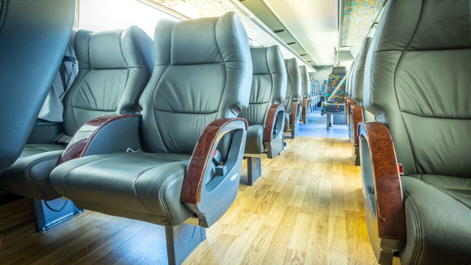 Passenger using onboard Wi-Fi and a USB charging port on a charter coach